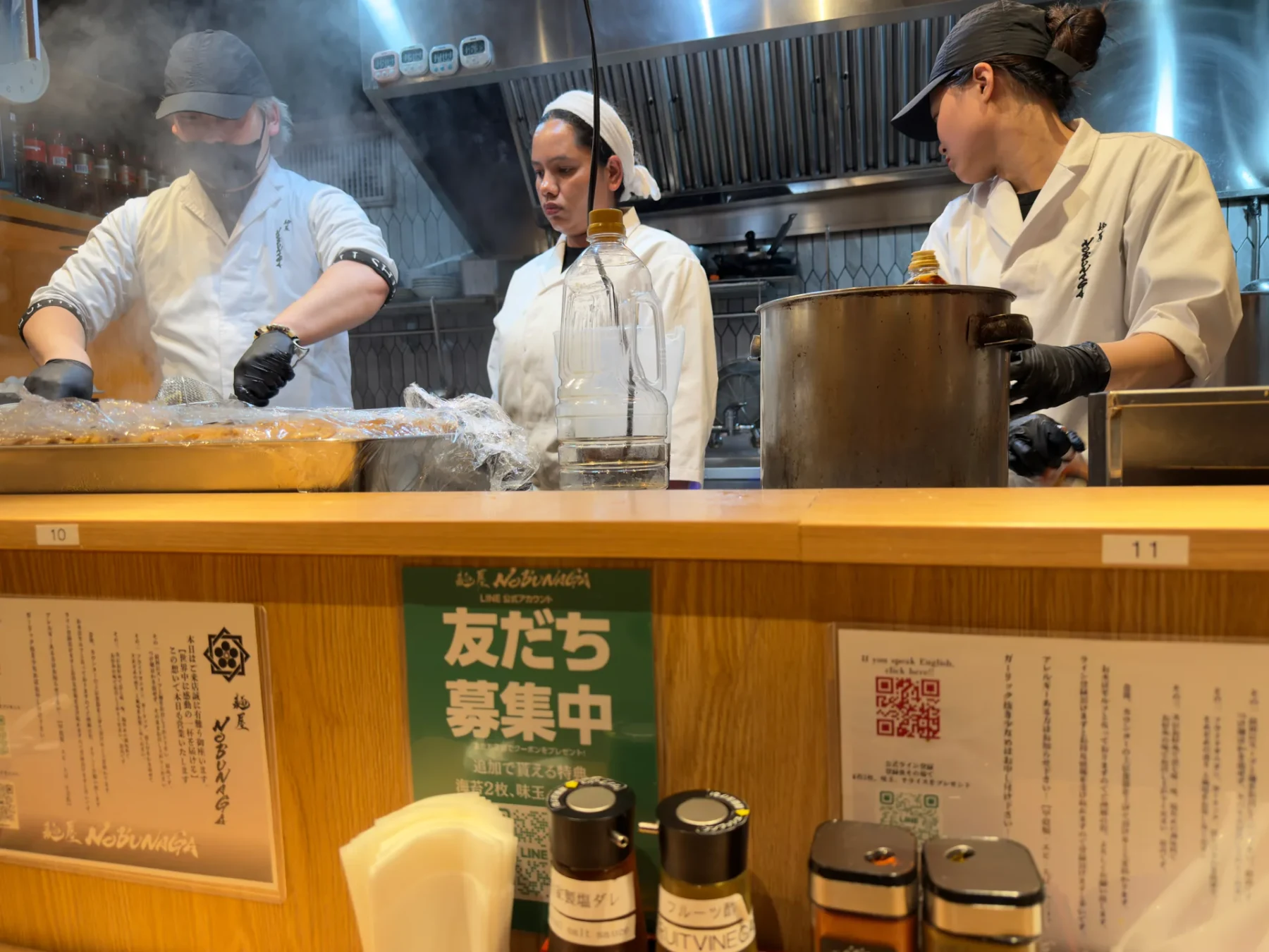 Cooks preparing food inside Nobunaga Ramen in Tokyo.